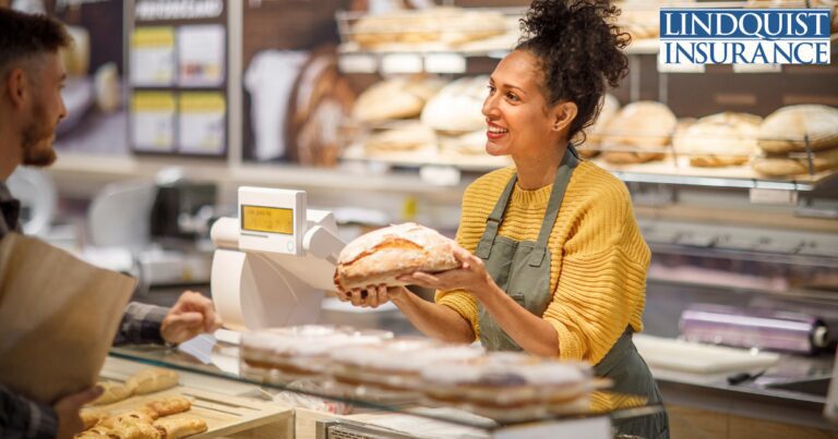 woman holding loaf of bread in bakery Lindquist Insurance