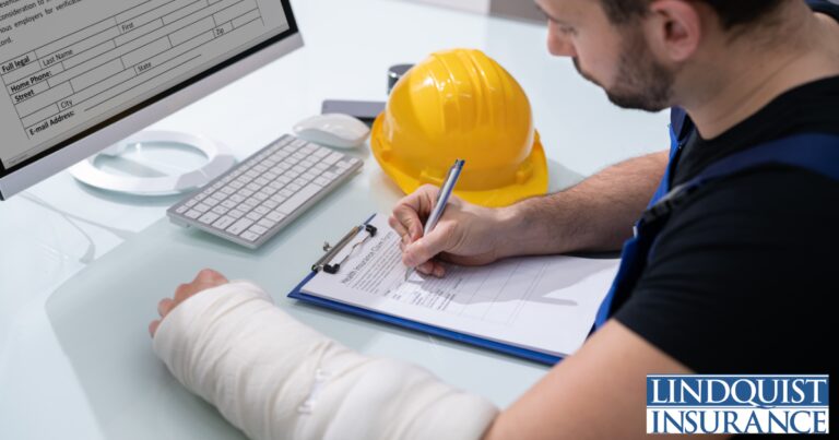 man with cast on his arm completing a report Lindquist Insurance