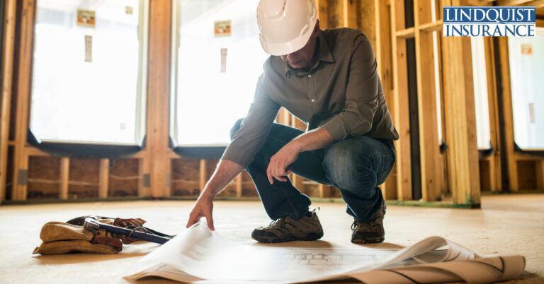 contractor looking at blueprint in building Lindquist Insurance